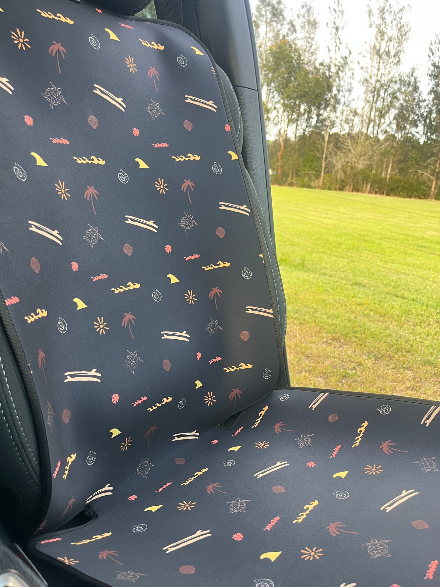 Car seat cover with a pattern of small icons on a dark background