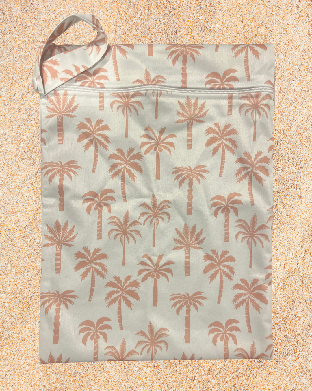 Reusable shopping bag with palm tree pattern on a sandy background