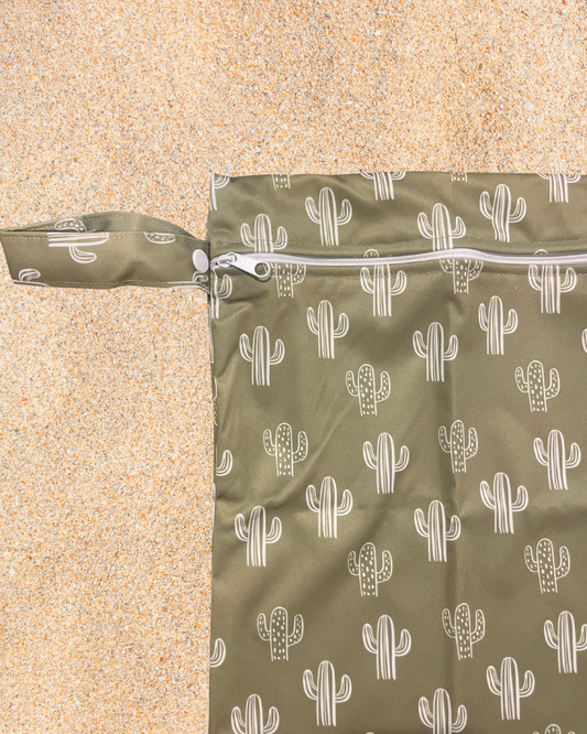 Green wet bag with white cactus pattern on a beige background