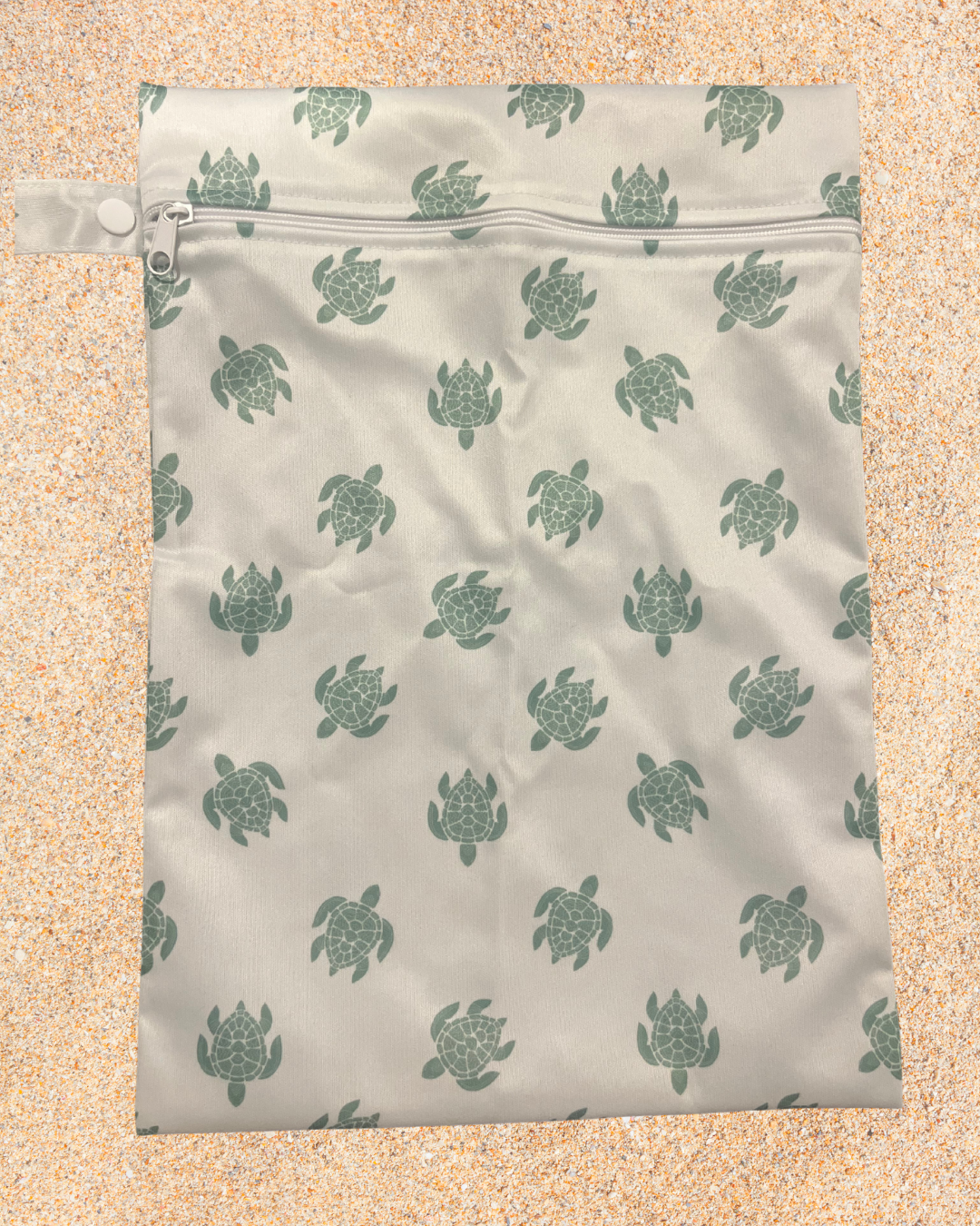 Reusable shopping bag with turtle pattern on a sandy background