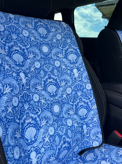 Blue ocean seashell car seat cover with a black car interior background