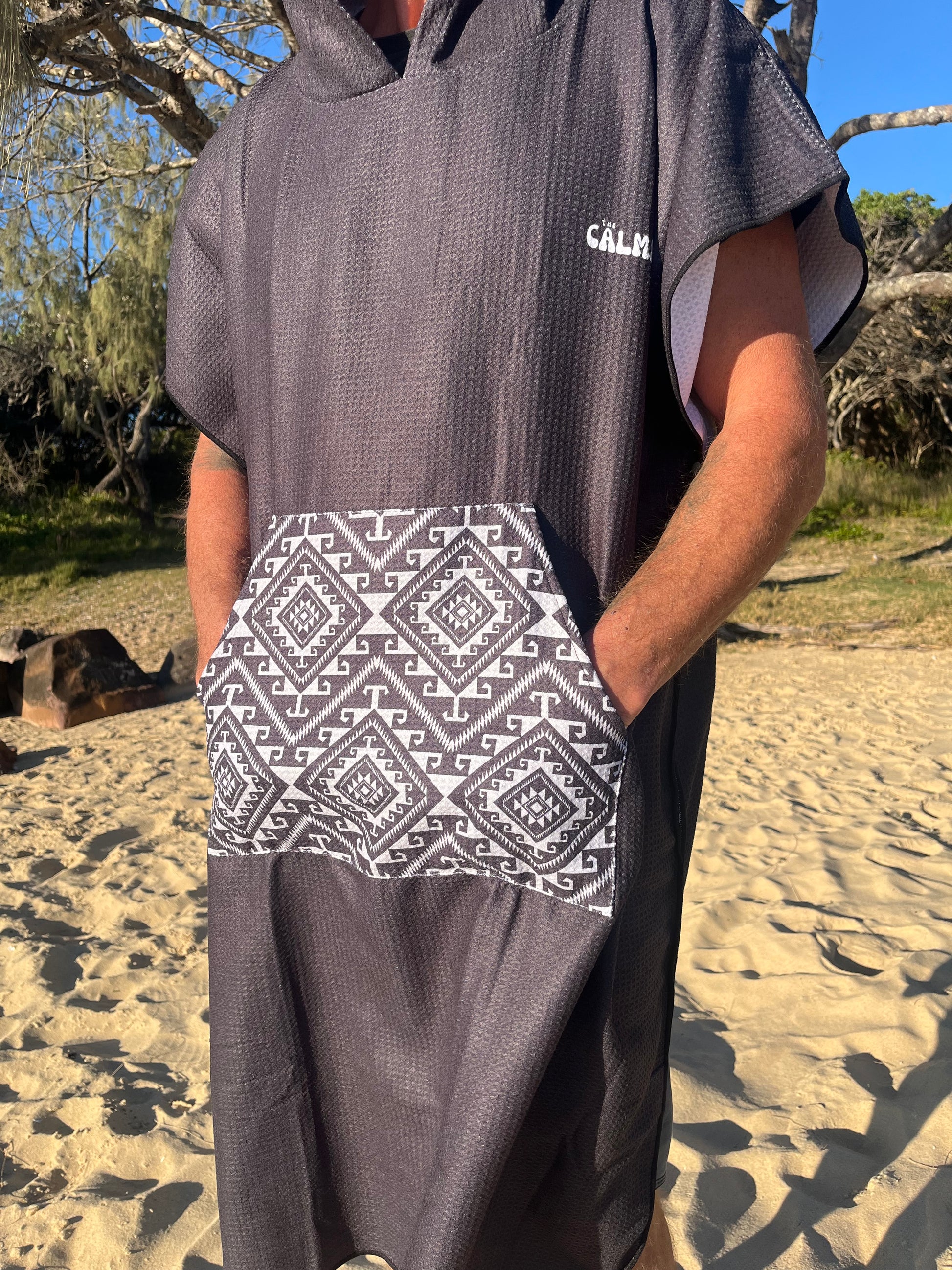 Black aztec hooded beach towel on a person on the beach