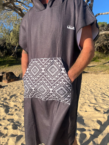 Black aztec hooded beach towel on a person on the beach