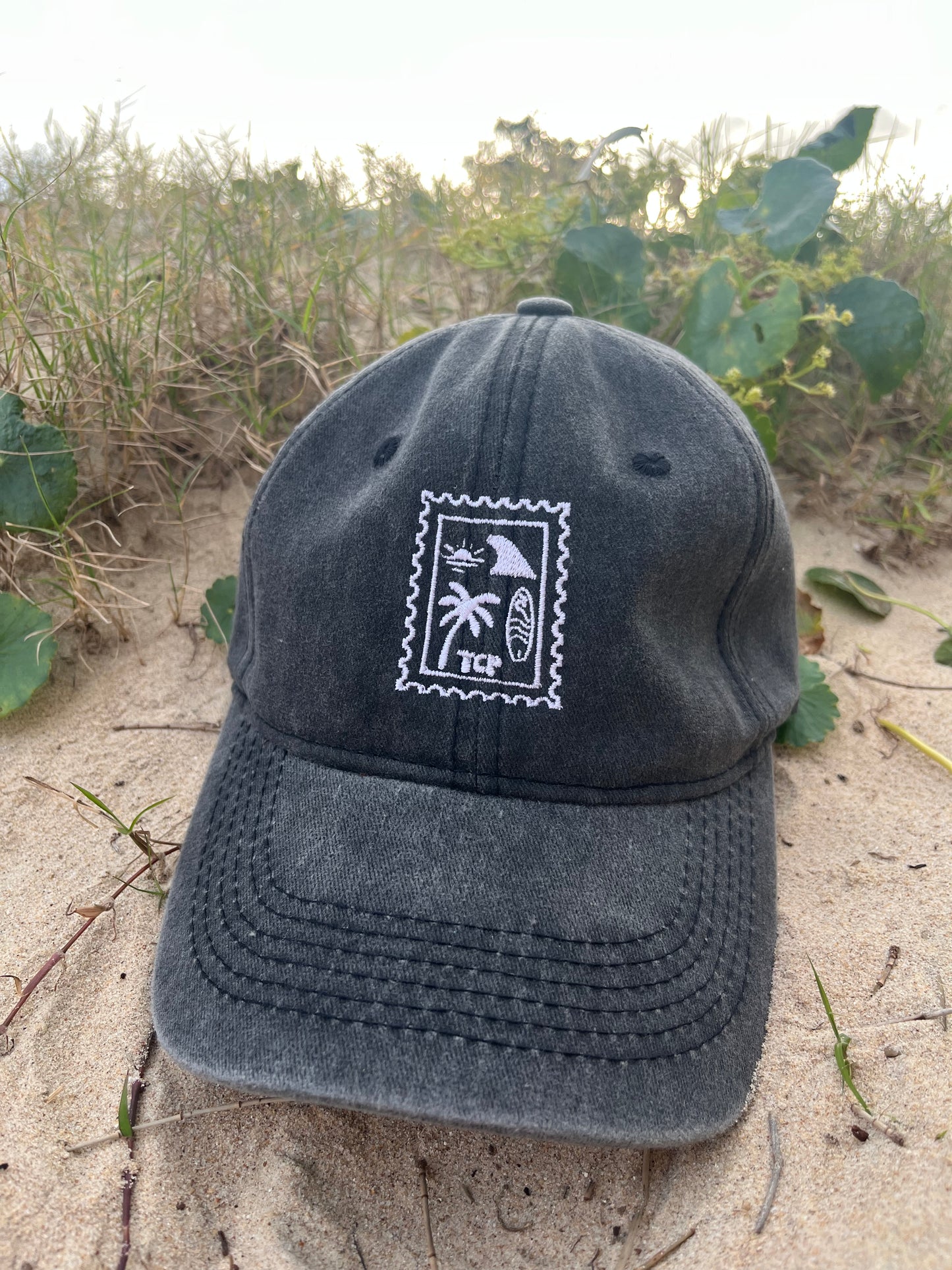 black vintage wash cap on sand