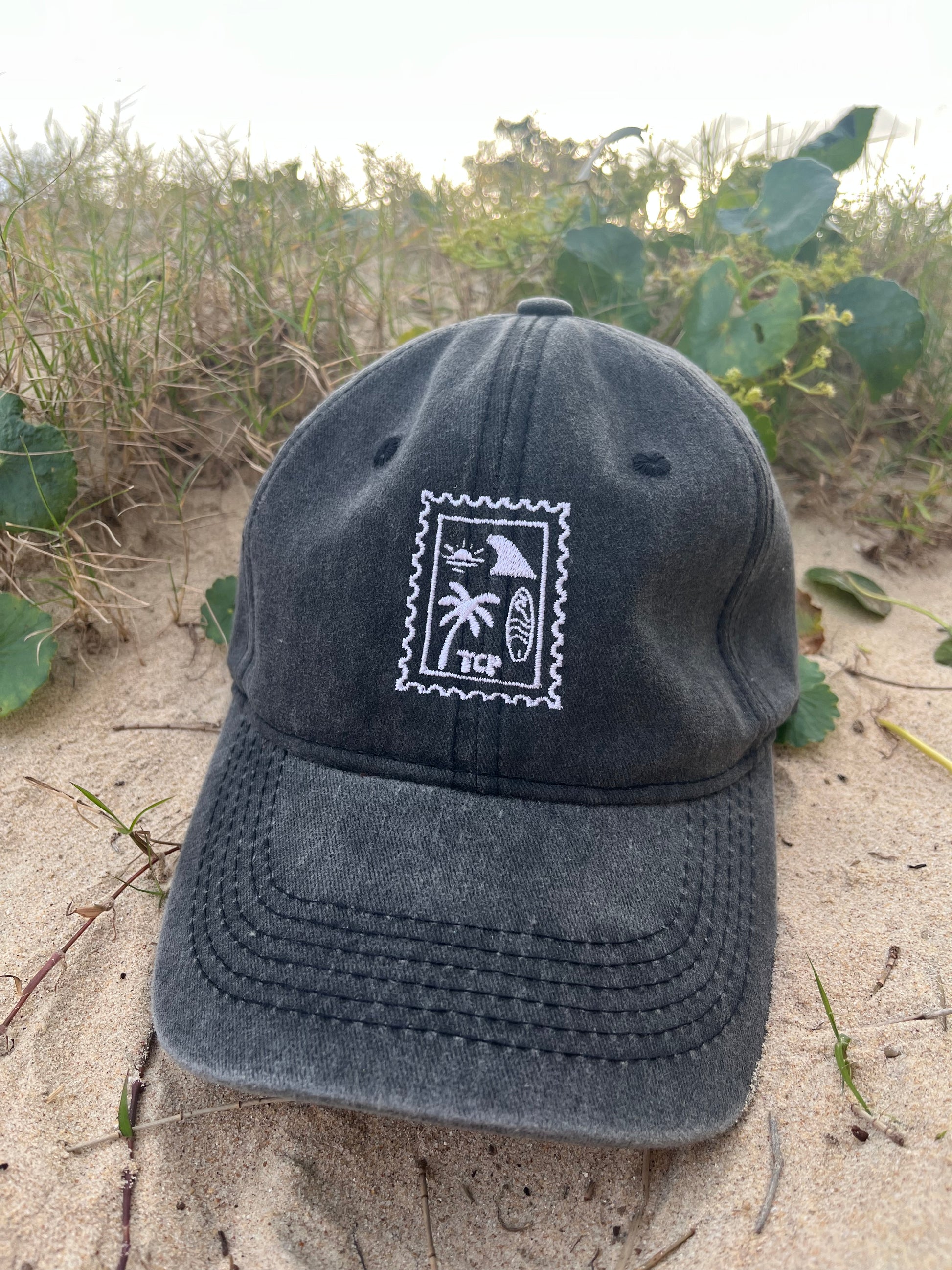 black vintage wash cap on sand