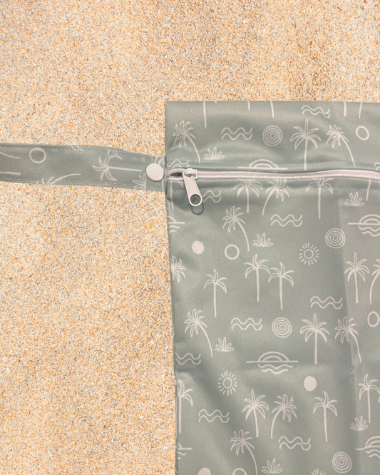 Green patterned wet bag on a sandy surface