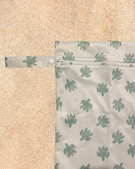 Reusable bag with turtle pattern on a sandy background