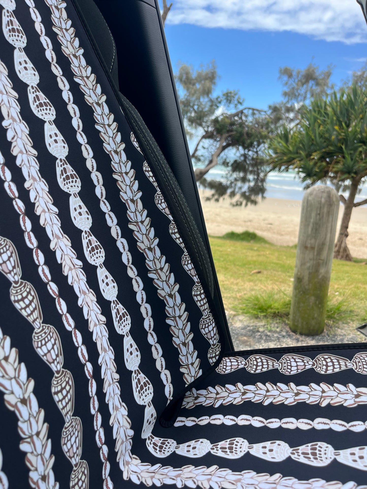 Seashell Lei patterned Car Seat Covers in the car. Black and white in colour. Close up of the detail of shells