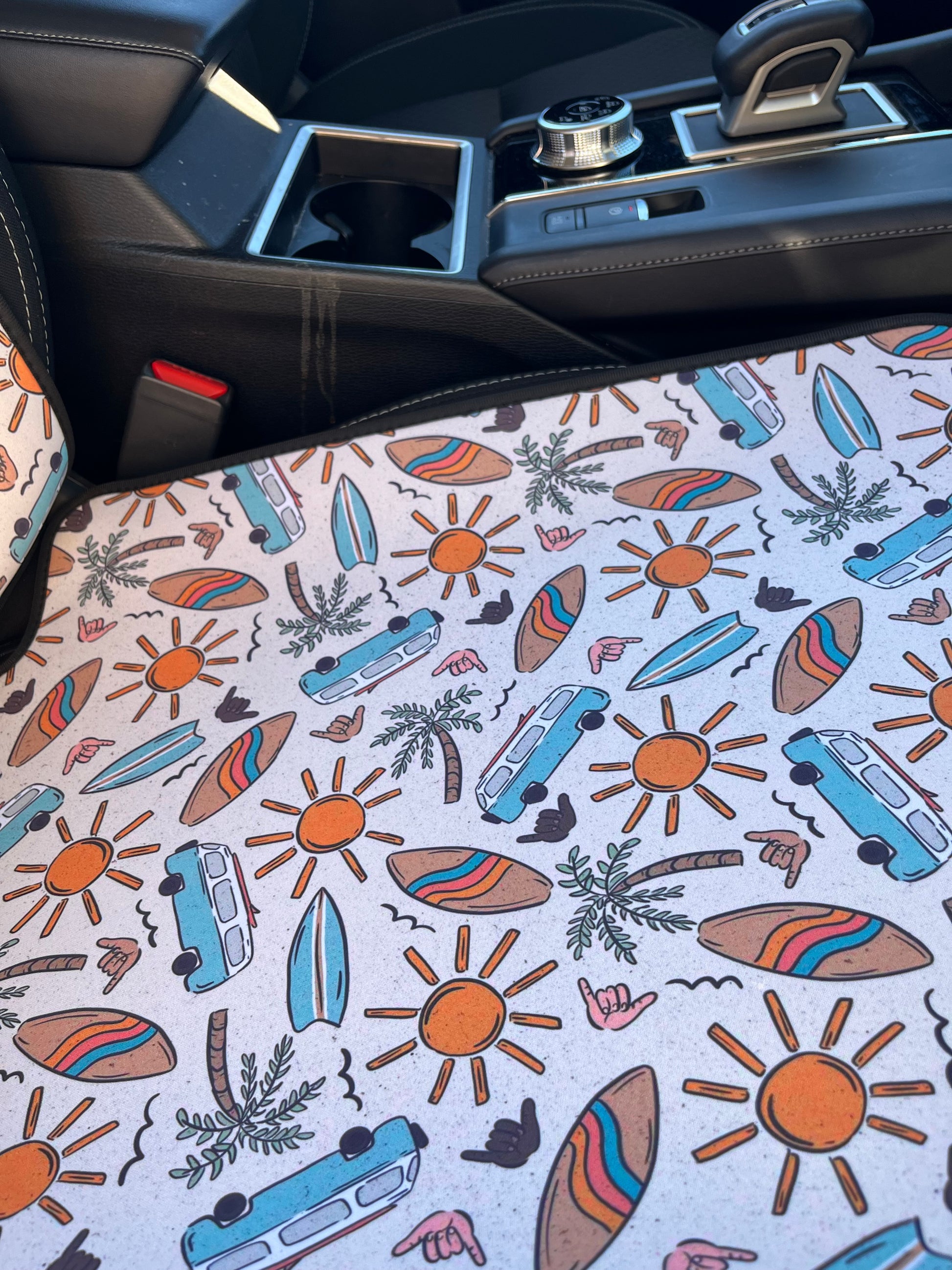 Combi vans, suns, palm trees, and surfboard print in tans/browns, yellow and aqua. Shown on car seat