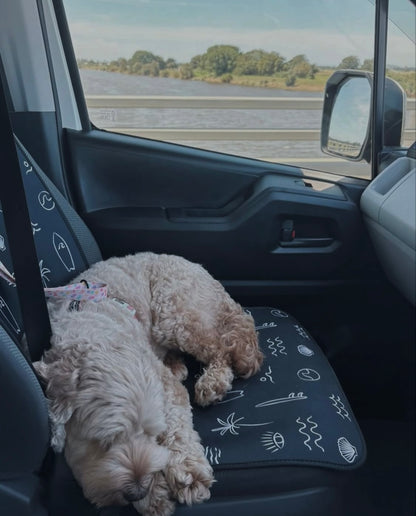 Black and white surf print. Includes surfboards, shells, palm tree, and waves. Set of two shown on the front seats. Easy to install made out of neoprene. Dog sleeping on passenger seat car seat cover. Great protection