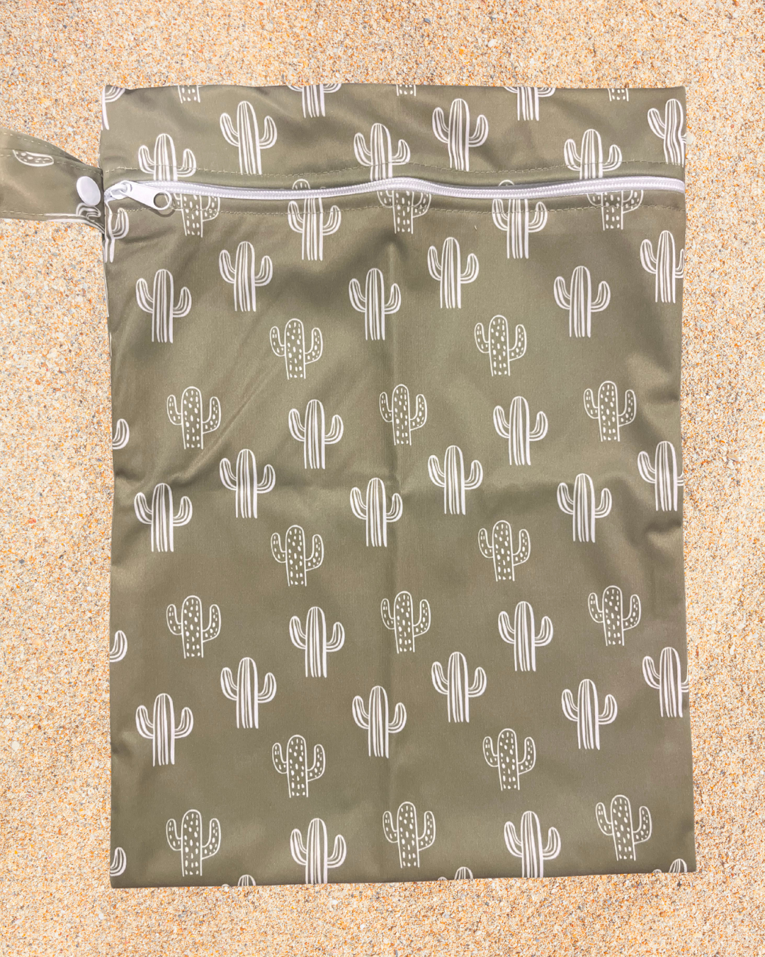 Green wet bag with white cactus pattern on a beige background