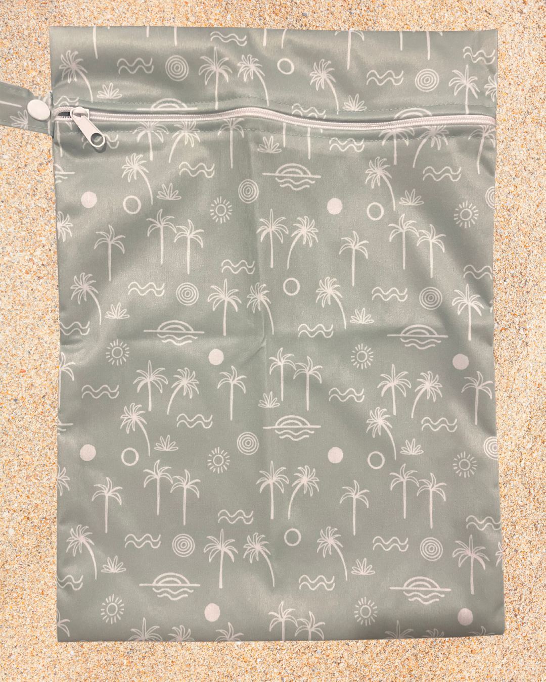 Reusable wet bag with palm tree pattern on a beige background