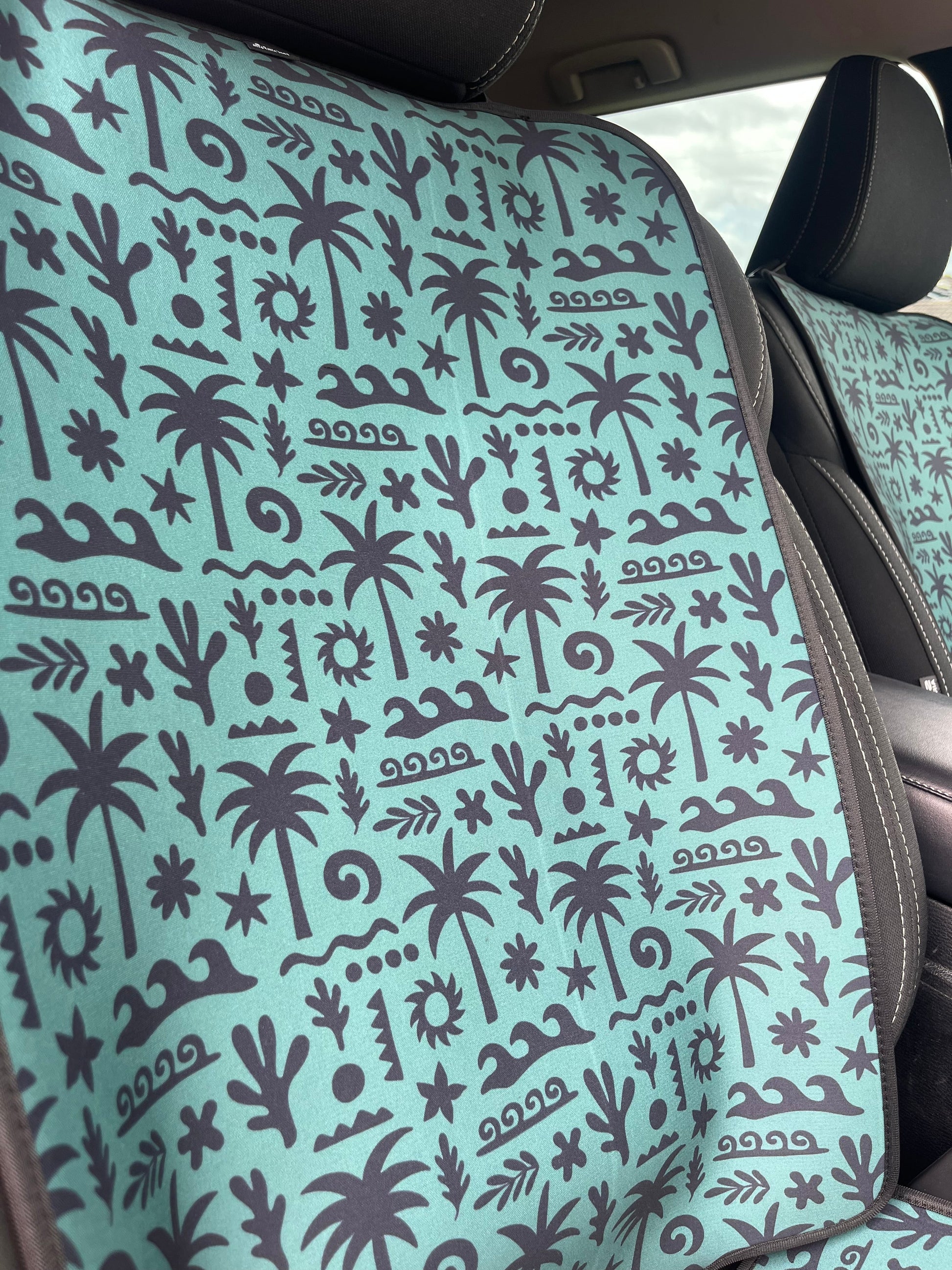 Patterned seat cover with palm tree design on a vehicle seat