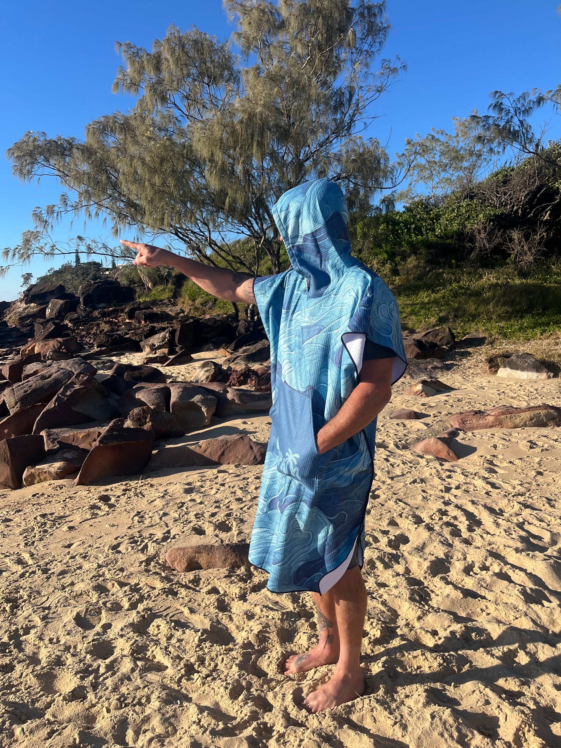 Person wearing blue hooded beach towel on the beach