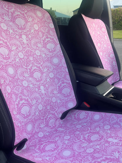 Car seat covers with pink shell pattern inside a vehicle