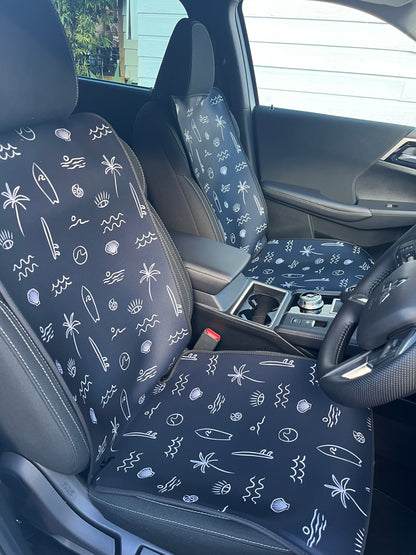 Black and white surf print. Includes surfboards, shells, palm tree, and waves. Set of two shown on the front seats. Easy to install made out of neoprene