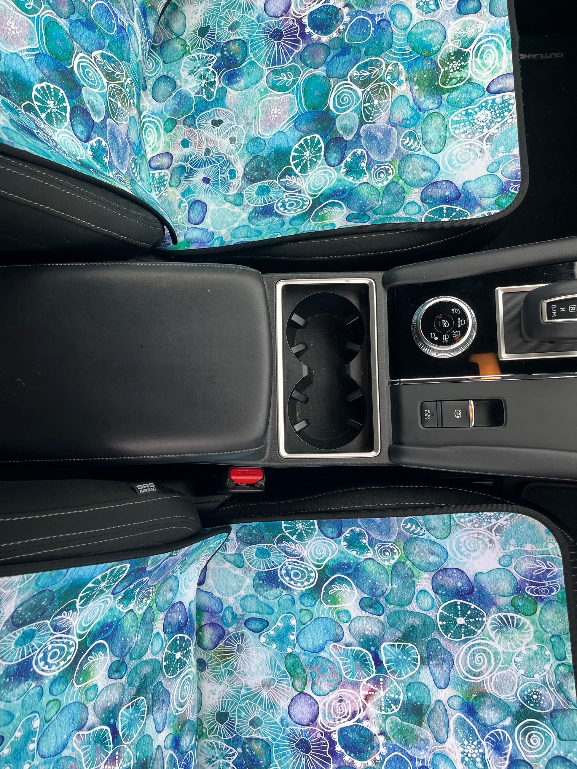 Seaglass print in Aqua tones. Shown on a car seat. Easy to install. Base view of car seat