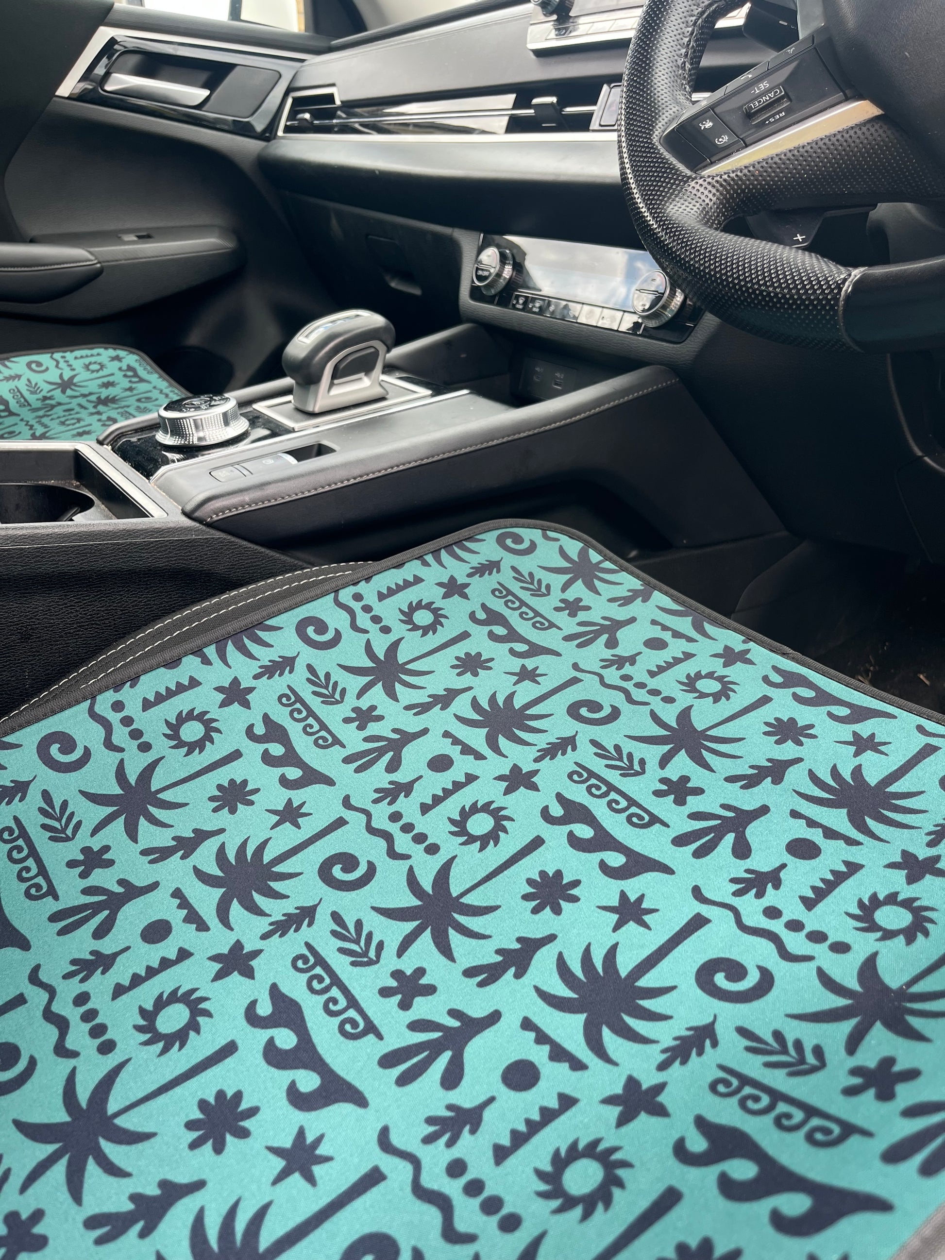 Car interior with a patterned seat cover on a black car seat